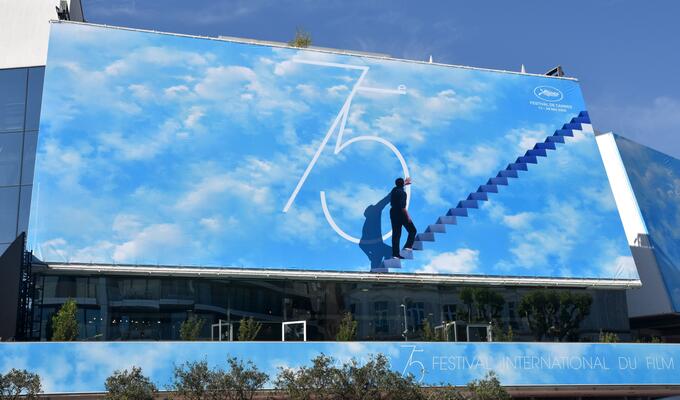 Putting up the billboard at the Cannes film festival 75th anniversary event